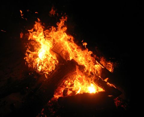 1993 Toyota 4Runner - A bright bonfire burns against a dark background, with logs visible within the flames.
