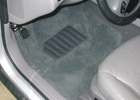 2000 Ford Taurus - Driver's footwell of a sedan after a carpet replacement, showing clean gray carpet with the molded black rubber dead pedal, hanging acceler…