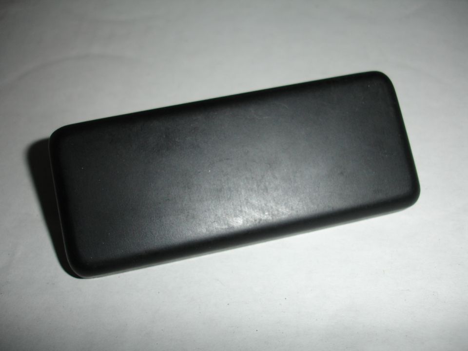Black rectangular object with rounded corners, viewed from a slight angle