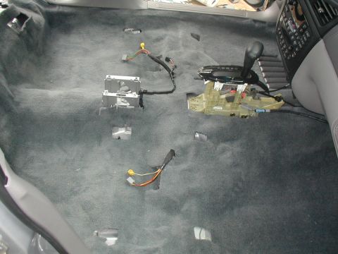 2000 Ford Taurus - Overhead view of a stripped car floor with fresh gray carpet laid in and the seats and console out, showing the exposed automatic shifter a…