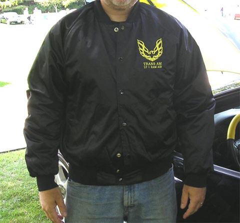 1984 Pontiac Fiero - A man wears a black jacket with the iconic Trans Am bird logo and 'LT1 RAM AIR' text.