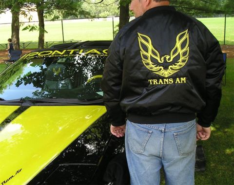 1984 Pontiac Fiero - Man in Trans Am jacket next to a car. The jacket and car both display Trans Am branding.
