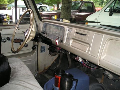1984 Pontiac Fiero - Interior view of an older truck, with multiple vehicles seen through the windows.