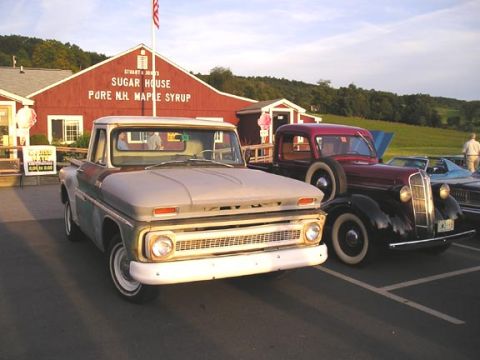 1984 Pontiac Fiero - Two classic pickup trucks are parked in front of a sugar house, one a 1965 Chevy C10 and the other a 1930s model.