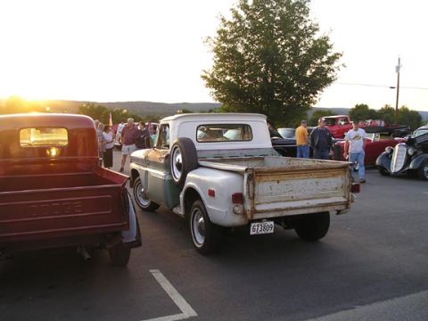 1984 Pontiac Fiero - A gathering of classic vehicles, including two pickup trucks, is seen at sunset.