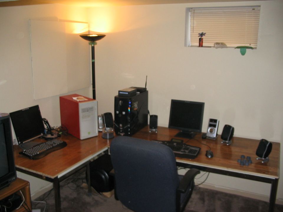 Computer desk with two monitors, keyboards, speakers, and desktop towers