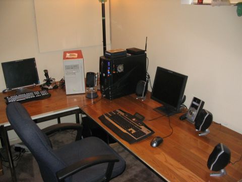 1986 Ford Bronco - A dual-computer setup occupies a large wooden desk, complete with multiple peripherals and a desk chair.