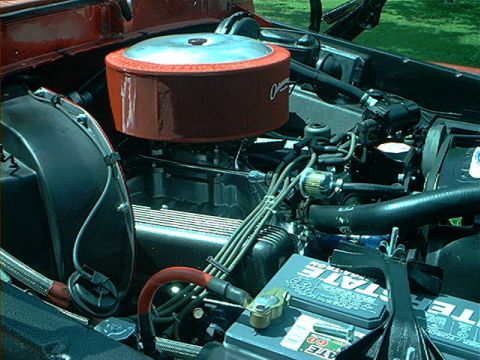 1978 Ford Bronco - Close-up view of a vehicle's engine bay, focusing on the air cleaner and battery components.