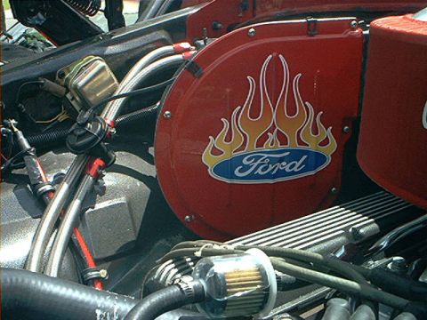 1978 Ford Bronco - A Ford engine component features a flame decal and the Ford logo, with various engine parts in the foreground.