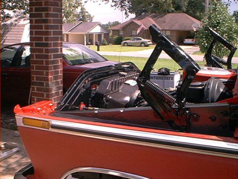 1978 Ford Bronco - A red 1978 Ford Bronco convertible is shown with its hood open, revealing the engine and an Interstate battery.