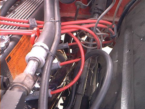 1978 Ford Bronco - The engine bay shows a tangle of red spark plug wires and various hoses, with some text visible on an orange label.