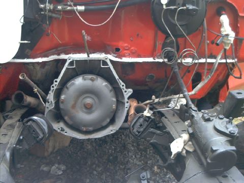 1978 Ford Bronco - Close-up view of vehicle engine components, including the transmission and firewall, with visible hoses and wiring.