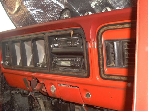 1978 Ford Bronco - The dashboard of this vehicle shows a red interior with aftermarket radios and air vents.