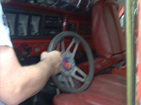 1978 Ford Bronco - Interior view of a vehicle with red seats and a steering wheel.