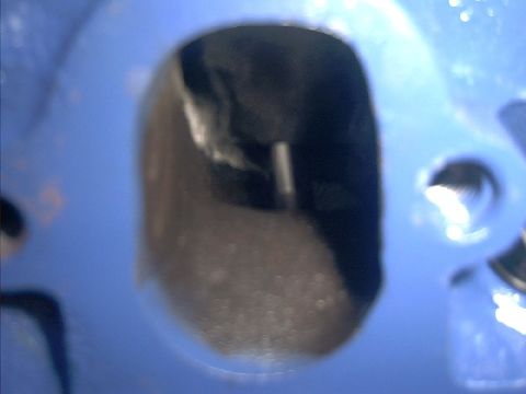 1978 Ford Bronco - Detail of an engine cylinder head intake port, showing the internal casting and surface texture.