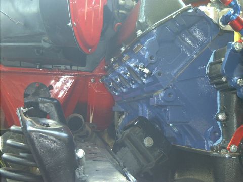 1978 Ford Bronco - Close-up view of a blue engine block with spark plugs and red engine bay components.