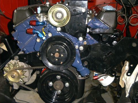 1978 Ford Bronco - Close-up view of engine components including pulleys, belts, and an oil filter.