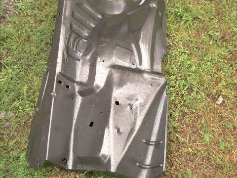 1978 Ford Bronco - This is a vehicle floor pan, likely from an older model, resting on a grassy area.