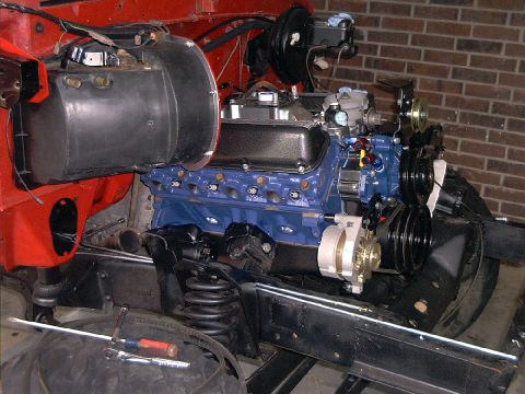 1978 Ford Bronco - Close-up view of a vehicle's engine bay, showing a blue V8 engine and associated components.
