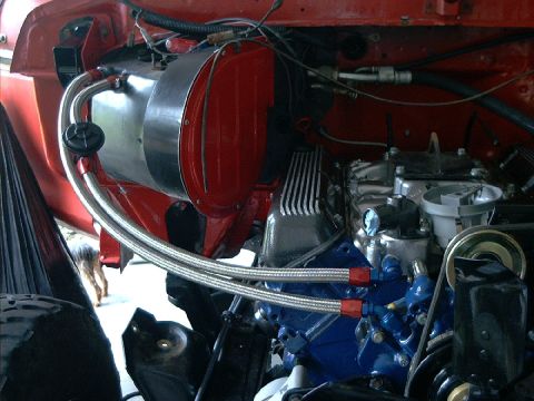 1978 Ford Bronco - Close-up view of an engine bay, showing a blue engine block and red heater assembly.