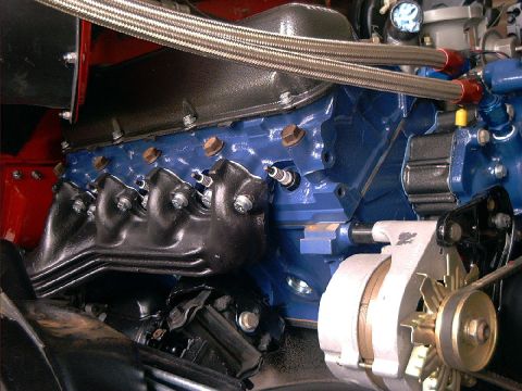 1978 Ford Bronco - Close-up view of a vehicle's engine components, including the block, manifolds, and alternator.