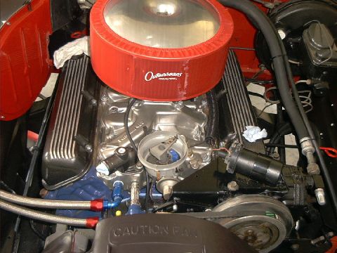 1978 Ford Bronco - Close-up view of a V8 engine bay a red air cleaner and chrome valve covers, with visible caution text.