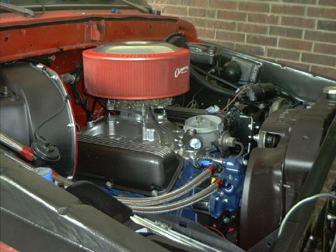1978 Ford Bronco - Close-up view of a modified engine bay, a prominent red air filter and braided hoses.