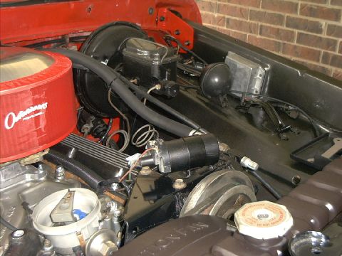 1978 Ford Bronco - Close-up view of the engine bay of a red vehicle, showing various engine components and wiring.