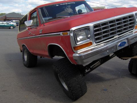1978 Ford Bronco - This red 1978 Ford Bronco features a prominent chrome grille and a lifted suspension, giving it a appearance.