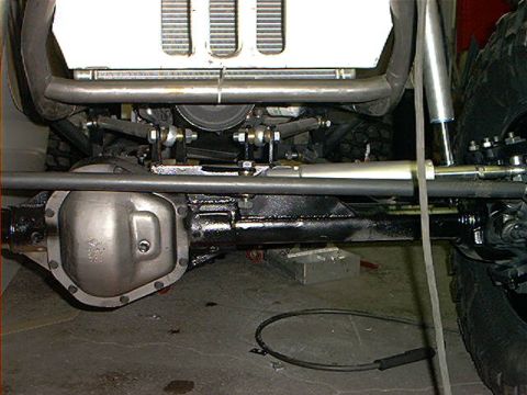 1978 Ford Bronco - The undercarriage of a modified off-road vehicle shows heavy-duty suspension and steering components.