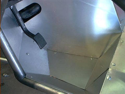 1978 Ford Bronco - The interior of a vehicle shows a custom metal footwell and a black brake pedal with visible text.