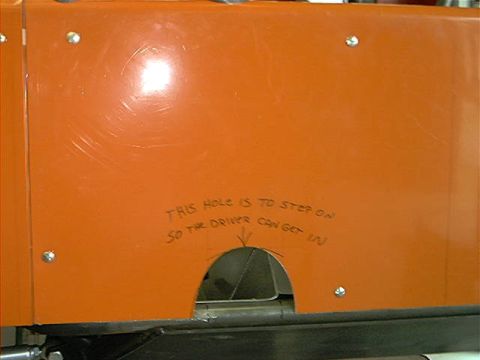 1978 Ford Bronco - A close-up of an orange panel with a cutout and handwritten instructions for vehicle entry.