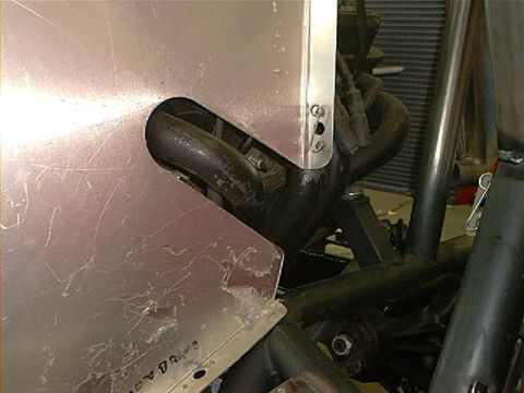 1978 Ford Bronco - Detail of an exhaust pipe exiting through a custom metal panel, likely part of a modified vehicle.