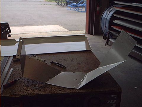 1978 Ford Bronco - Unfinished metal parts are laid out on a workbench, ready for assembly or further modification.