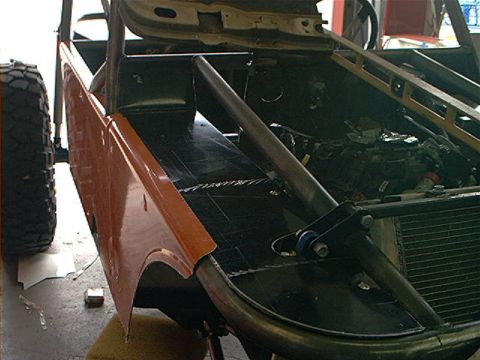 1978 Ford Bronco - This custom vehicle build features a roll cage and exposed engine components, with an orange fender on the side.