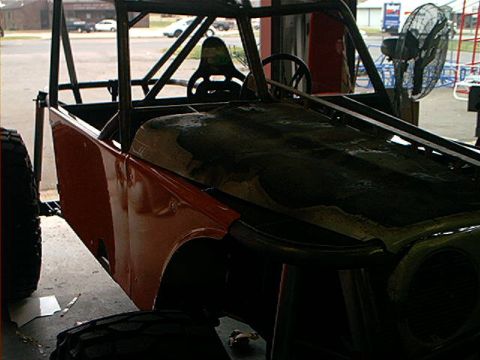 1978 Ford Bronco - Custom off-road vehicle frame with roll cage and orange body panels is under construction.