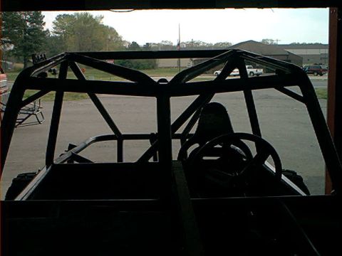 1978 Ford Bronco - The interior of a custom-built vehicle with a prominent roll cage is visible from the driver's perspective.