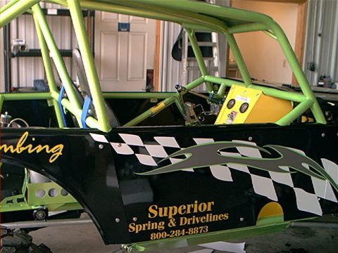 1978 Ford Bronco - This heavily modified vehicle has a custom roll cage and racing graphics, with visible company contact information.