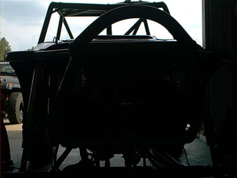 1978 Ford Bronco - A heavily modified vehicle with a custom roll cage is silhouetted against a bright background, with another vehicle visible to the left.