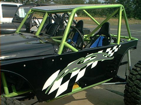1978 Ford Bronco - This custom buggy features a prominent green roll cage and racing seats, with checkered flag graphics on the side panels.