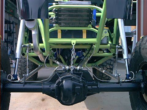 1978 Ford Bronco - This custom off-road vehicle features a heavily modified rear axle and suspension system with a prominent green roll cage.
