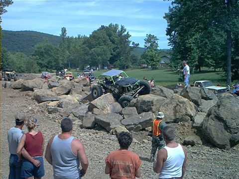 1978 Ford Bronco - Multiple vehicles and spectators gather around a custom off-road buggy navigating a challenging rocky course.