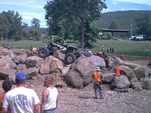 1978 Ford Bronco - Spectators watch as a custom buggy attempts to climb over large rocks during an off-road event.
