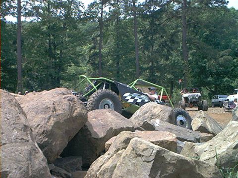 1978 Ford Bronco - A custom off-road buggy navigates a rocky terrain with other vehicles in the background.