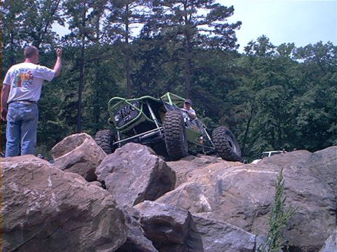 1978 Ford Bronco - Off-road buggy tackling a rocky terrain with a spectator watching.