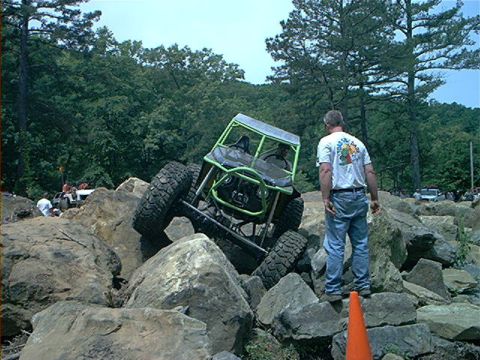 1978 Ford Bronco - A custom off-road buggy maneuvers through a rocky terrain, with a spectator observing the challenging climb.