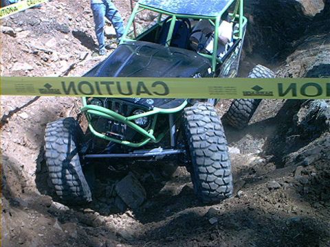 1978 Ford Bronco - This custom buggy is designed for extreme off-road conditions, navigating a challenging dirt obstacle.