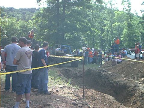 1978 Ford Bronco - Spectators gather to watch an off-road vehicle traverse a challenging muddy course.