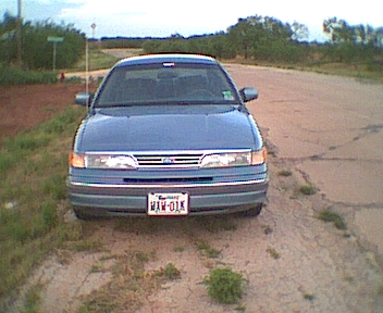 1994 Ford Crown Victoria - Front view of a blue 1994 Ford Crown Victoria parked on a dirt road.