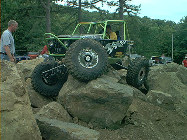 Custom rockcrawler buggy with green roll cage on rocks